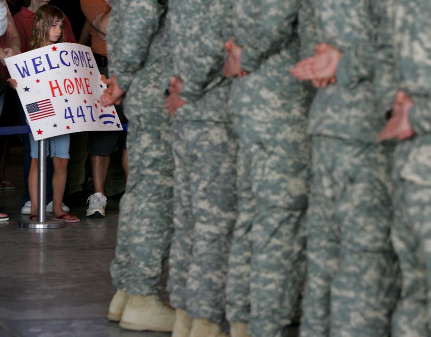 Courtney Cain, 7, of Uniontown, Ohio, holds a sign Friday for her cousin, Seth Koosed, a soldier from the 447th MP Co. returning home from Afghanistan. Koosed and others were honored at a ceremony at the MAPS Air Museum at the Akron-Canton Airport in Green, Ohio. (Associated Press/Akron Beacon Journal, Phil Masturzo)