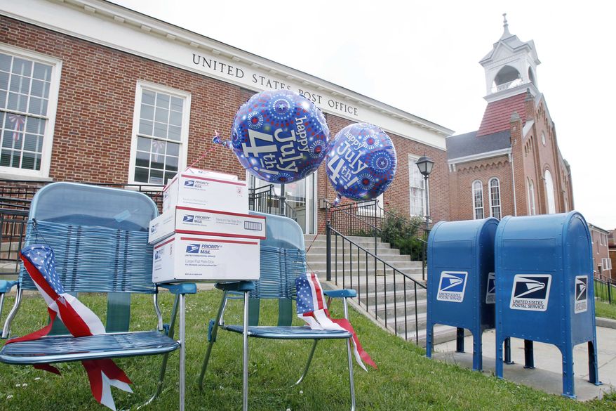 In this June 29, 2010 photo, a pair of blue chairs decorated with holiday balloons and the postal services "flat-rate" boxes are on the lawn in front of the post office in Canonsburg, Pa. Postal officials scheduled a briefing Tuesday, July 6, 2010 to discuss the amount of the increase, which will go to the independent Postal Regulatory Commission for review. (AP Photo/Keith Srakocic)