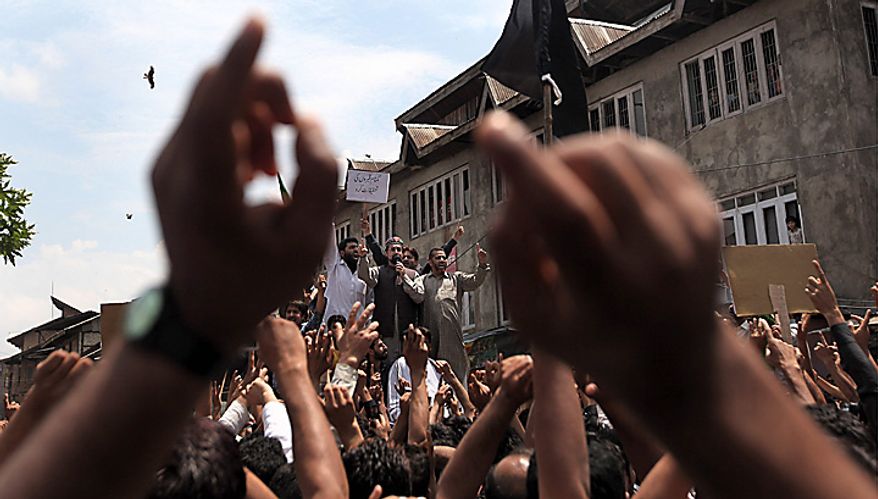 Chairman of the All Parties Hurriyat Conference Mirwaiz Umar Farooq, center top, shouts freedom slogans during a protest march against the fresh killings of two youths in Srinagar, India, Tuesday, July 6, 2010. Government forces fired on hundreds of rock-throwing protesters in Indian Kashmir on Tuesday, killing one person and wounding two others as a seven-day curfew was lifted, locals and officials said. Another youth Muzaffar Bhat was allegedly killed by paramilitary soldiers Monday. (AP Photo/Dar Yasin)