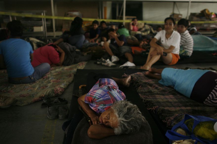 People rest on the floor of a warehouse in Nuevo Laredo, northeastern Mexico, after being evacuated from the nearby town of Ciudad Anahuac, Tuesday, July 6, 2010. About 18,000 people were evacuated Tuesday from Ciudad Anahuac where authorities opened a dam's floodgates for fear it would overflow from rains that accompanied Hurricane Alex. (AP Photo/Miguel Tovar)
