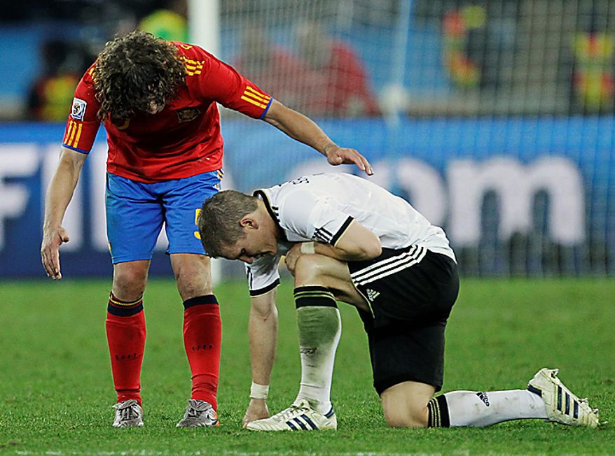 Spain's Carles Puyol, left, comforts Germany's Bastian Schweinsteiger, right, following the World Cup semifinal soccer match between Germany and Spain at the stadium in Durban, South Africa, Wednesday, July 7, 2010. Spain defeated Germany 1-0. (AP Photo/Matt Dunham)