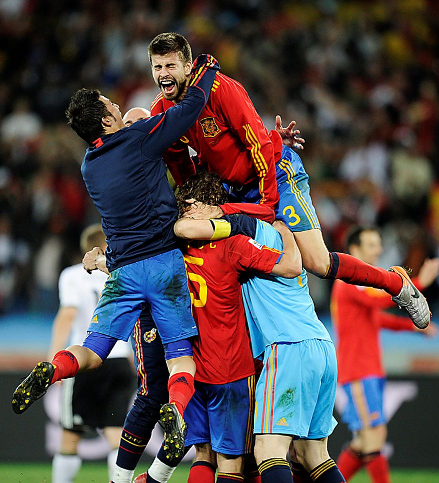 Spain's David Villa, left, Spain's Carles Puyol, second from left at bottom, Spain goalkeeper Iker Casillas, bottom right, and Spain's Gerard Pique, top right, celebrate following the World Cup semifinal soccer match between Germany and Spain at the stadium in Durban, South Africa, Wednesday, July 7, 2010. Spain defeated Germany 1-0. (AP Photo/Martin Meissner)