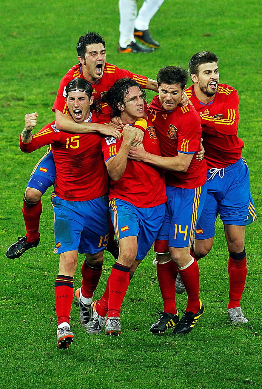 Spain's Carles Puyol, third from left, celebrates after scoring with teammates, from left, Sergio Ramos, David villa, top, Xabi Alonso and Gerard Pique during the World Cup semifinal soccer match between Germany and Spain at the Moses Mabhida stadium in Durban, South Africa, Wednesday July 7, 2010. (AP Photo/Themba Hadebe)