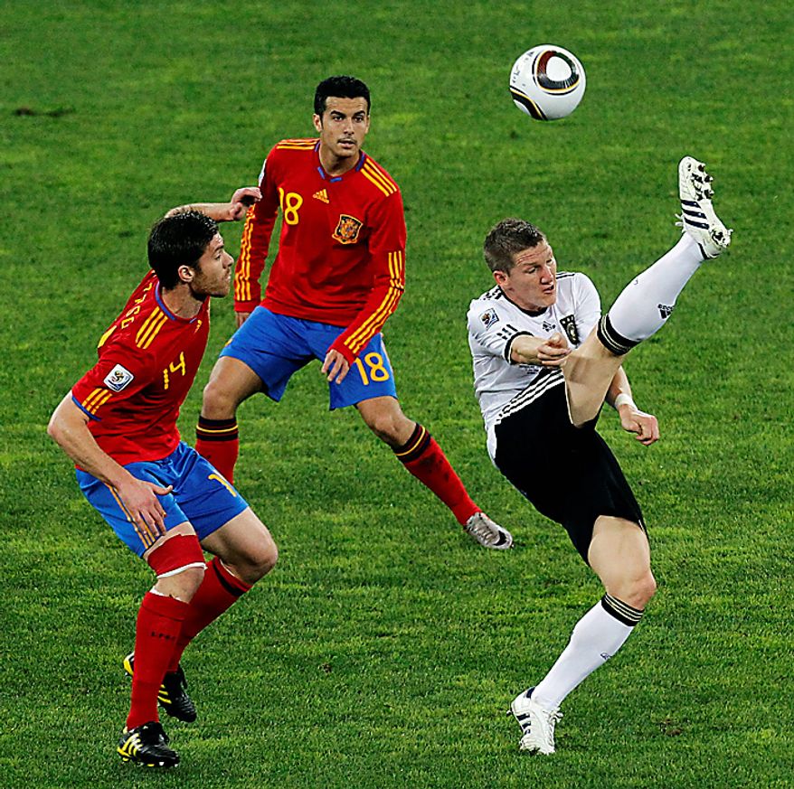 Germany's Bastian Schweinsteiger, right, kicks the ball as Spain's Xabi Alonso, left, as Pedro Rodriguez, center, looks on during the World Cup semifinal soccer match between Germany and Spain at the Moses Mabhida stadium in Durban, South Africa, Wednesday July 7, 2010. (AP Photo/Themba Hadebe)