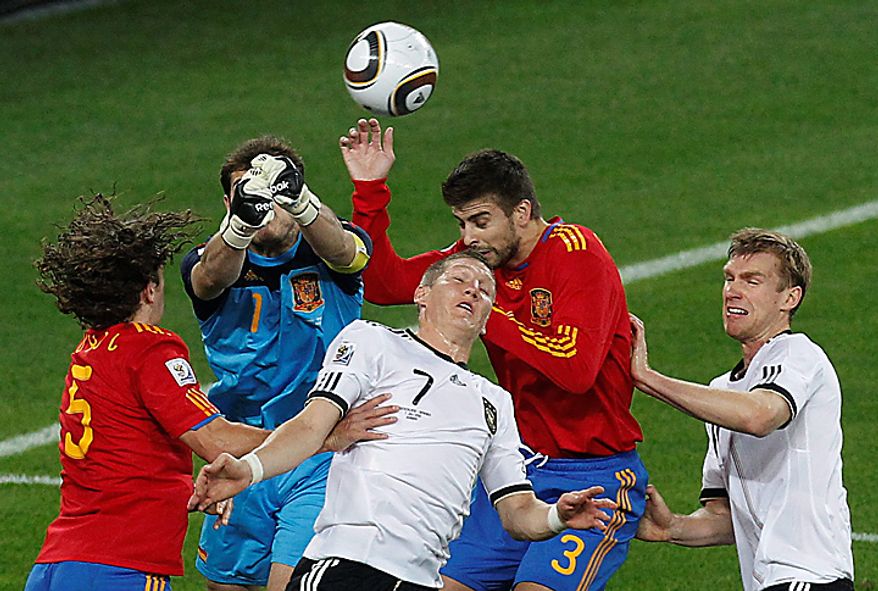 Spain goalkeeper Iker Casillas, second from left, punches away the ball from Germany's Bastian Schweinsteiger, bottom center, during the World Cup semifinal soccer match between Germany and Spain at the Moses Mabhida stadium in Durban, South Africa, Wednesday July 7, 2010. (AP Photo/Themba Hadebe)