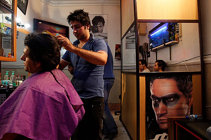 An Iranian barber cuts hair in his barber shop in midtown Tehran, Iran, Wednesday, July 7, 2010. An Iranian fashion organization has issued a new list of culturally appropriate haircuts for men, possibly indicating a new crackdown on male attire after years of strict rules for women, Iranian media reported. (AP Photo/Vahid Salemi)