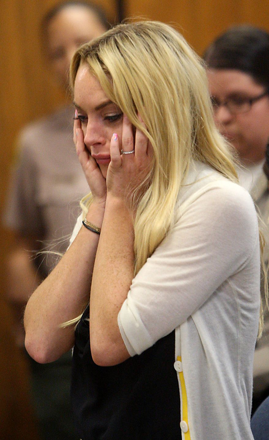 Actress Lindsay Lohan (L) reacts with her attorney Shawn Chapman Holley following her sentencing by Superior Court Judge Marsha Revel during a probation status hearing in Beverly Hills, California on July 6, 2010. Revel sentenced Lohan to 90 days in jail Tuesday after ruling she violated probation in a 2007 drug case by failing to attend court-ordered alcohol education classes. UPI/David McNew/Pool