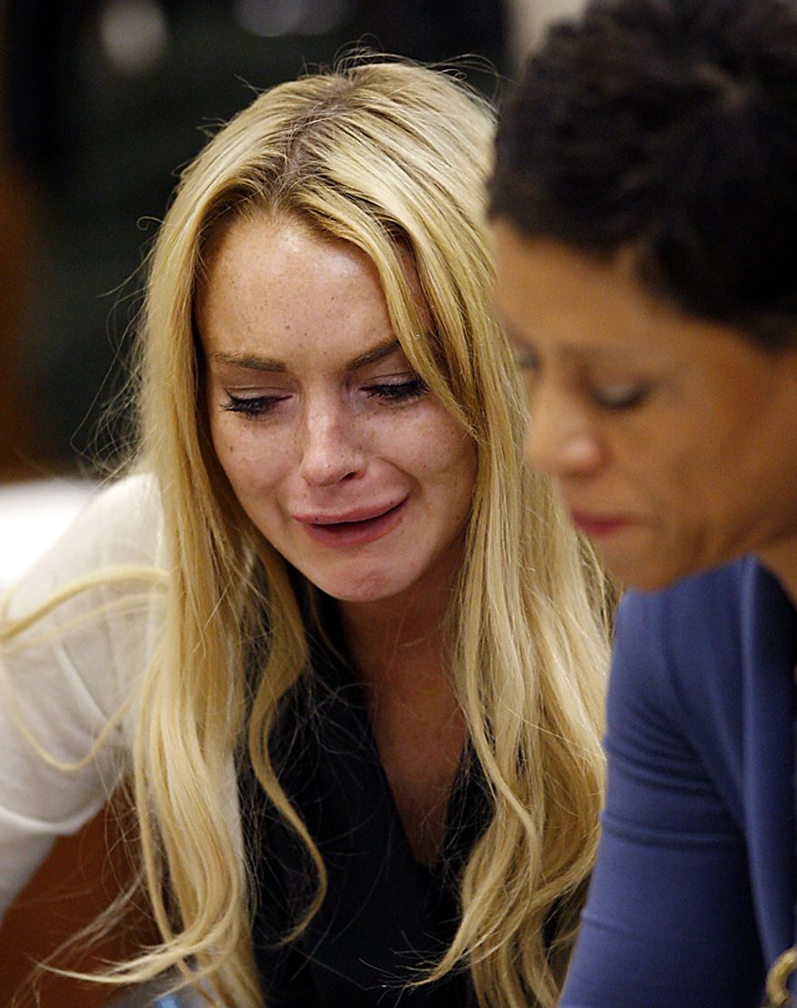 Actress Lindsay Lohan (L) reacts with her attorney Shawn Chapman Holley following the sentencing by Superior Court Judge Marsha Revel during a probation status hearing in Beverly Hills, California on July 6, 2010. Revel sentenced Lohan to 90 days in jail Tuesday after ruling she violated probation in a 2007 drug case by failing to attend court-ordered alcohol education classes. UPI/David McNew/Pool
