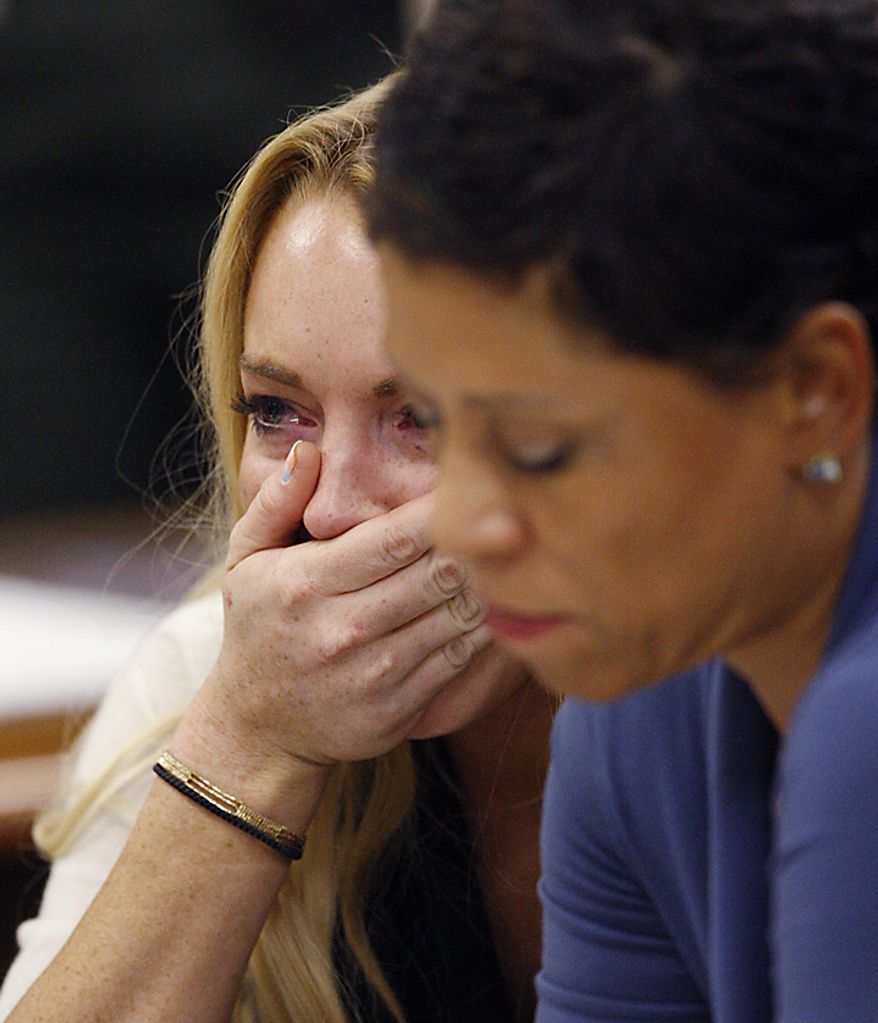 Actress Lindsay Lohan (L) reacts with her attorney Shawn Chapman Holley following the sentencing by Superior Court Judge Marsha Revel during a probation status hearing in Beverly Hills, California on July 6, 2010. Revel sentenced Lohan to 90 days in jail Tuesday after ruling she violated probation in a 2007 drug case by failing to attend court-ordered alcohol education classes. UPI/David McNew/Pool