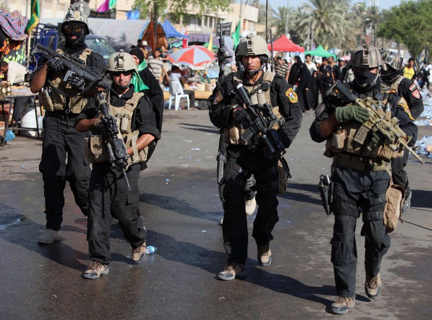 Iraqi security forces are seen on the street as Shi'ite pilgrims head to the Imam Moussa Kadhim shrine, on the final day of the annual commemoration of the saint's death, in the Shi'ite district of Kazimiyah in Baghdad, Thursday, July 8, 2010. Hundreds of thousands of devout Shi'ites from across the country walk to Baghdad to take part in the occasion. Iraqi officials say a handful of have been killed by bombs targeting pilgrims taking part in the final day of the Shi'ite religious holiday, a day after scores of pilgrims were killed Wednesday in a suicide attack as they passed through a Sunni neighborhood.(AP Photo/Karim Kadim)