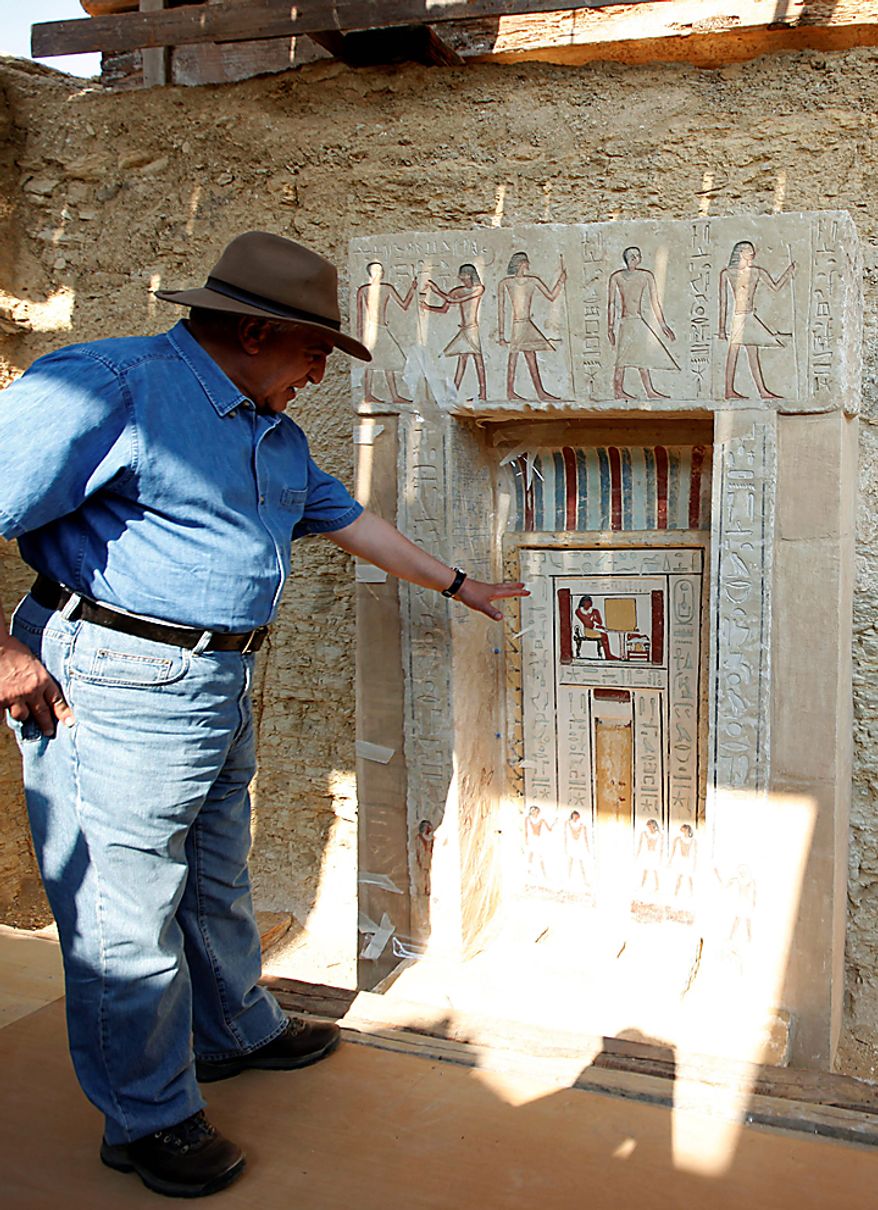 Egyptian Antiquities chief Zahi Hawass shows to the media the false door of the unearthed tomb that belongs to Shendwas, the father of Khonsu, both of whom served as heads of the royal scribes during the Old Kingdom, in Saqqara near Cairo, Egypt, Thursday, July 8, 2010. Egyptian archaeologists have unveiled their latest discovery - two 4,300-year-old tombs carved out of stone and unearthed in the ancient necropolis of Saqqara near Cairo. (AP Photo/Nasser Nasser)