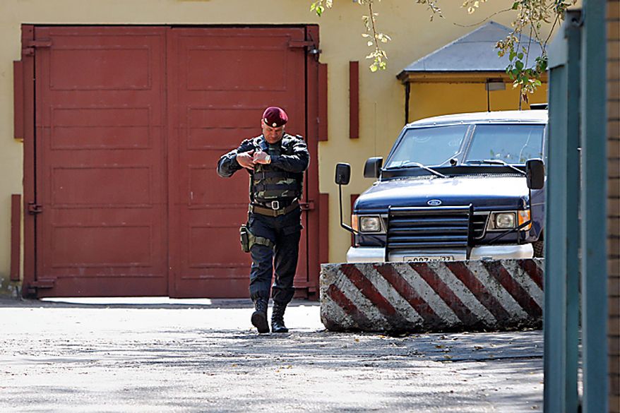 An officer of Russia's Federal Service for the Execution of Penal Sentences (FSIN) special forces walks near an armored vehicle before leaving Moscow's Lefortovo prison, where Igor Sutyagin, an arms researcher convicted of spying for the West, was earlier reportedly transferred, Thursday, July 8, 2010. A lawyer for Sutyagin says he reportedly has been flown to Vienna in what appeared to be the first step of a Russia-U.S. spy swap.(AP Photo/Alexander Zemlianichenko)