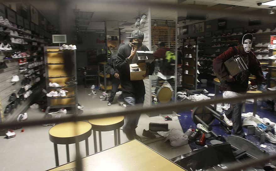 Unidentified people loot a Foot Locker store in Oakland, Calif., following an involuntary manslaughter verdict in Johannes Mehserle's trial on Thursday, July 8, 2010. A white former San Francisco Bay Area Rapid Transit police officer, Mehserle was found guilty of involuntary manslaughter in Los Angeles for shooting unarmed black man Oscar Grant on New Year's Day 2009 at a BART station in Oakland. (AP Photo/Jeff Chiu)