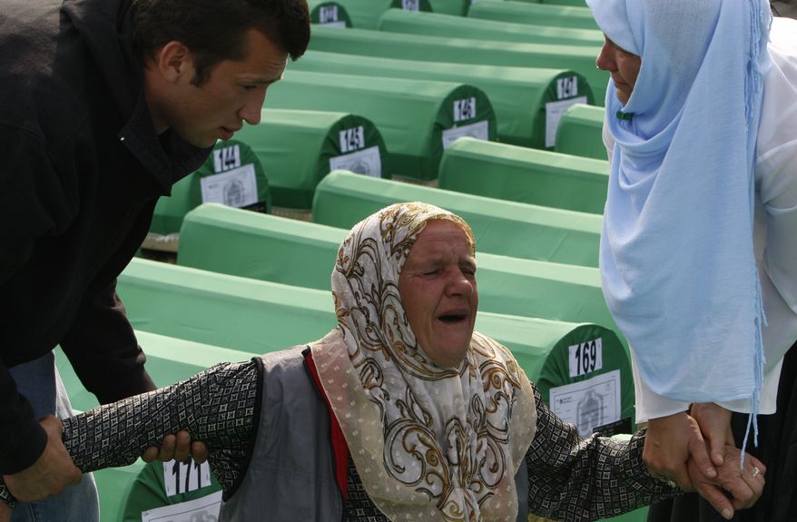 A grieving Bosnian Muslim woman is comforted near the coffin of her relative, a victim of the 1995 Srebrenica massacre, in Potocari, Bosnia, on Sunday, July 11, 2010. Thousands gathered in the eastern Bosnian town of Srebrenica to bury hundreds of massacre victims on the 15th anniversary of the worst crime in Europe since the Nazi era. (AP Photo/Amel Emric)