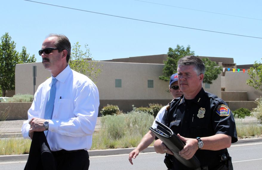 Albuquerque Mayor Richard Berry, left, and Police Chief Ray Schultz, right, leave a press conference near the scene of a deadly shooting in Albuquerque, N.M., on Monday, July 12, 2010. Police said a man entered a building and shot nine people, five of whom died. Police said the gunman was found inside the building dead of a self-inflicted gunshot wound. (AP Photo/Susan Montoya Bryan)