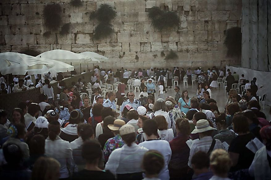 Israeli and international members of the Women of the Wall organization are seen through a screen as they pray at the Western Wall, Judaism's holiest site, in Jerusalem's Old City, Monday, July 12, 2010. Anat Hoffman, the chairwoman of the Women of the Wall, was arrested for carrying a biblical scroll at a Judaism's holiest site on Monday in contravention of an Israeli high court ruling that bars women from carrying the holy texts in the area of the Western Wall, said police spokesman Micky Rosenfeld. (AP Photo/Tara Todras-Whitehill)