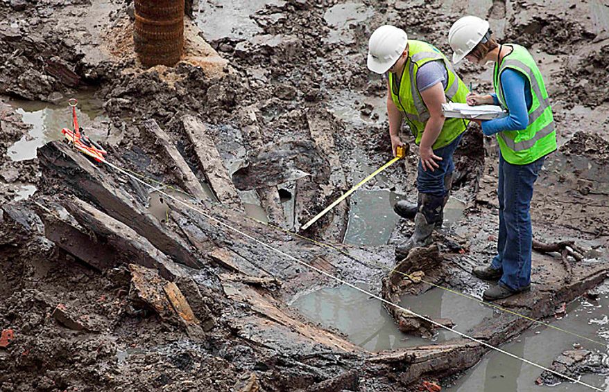 Archeologists Elizabeth Meade, left, and Molly McDonald take measurements of the wood hull of a 32-foot-long (9.75 meters) 18th century boat at the World Trade Center site, Thursday, July 15, 2010 in New York. (AP Photo/Mark Lennihan)