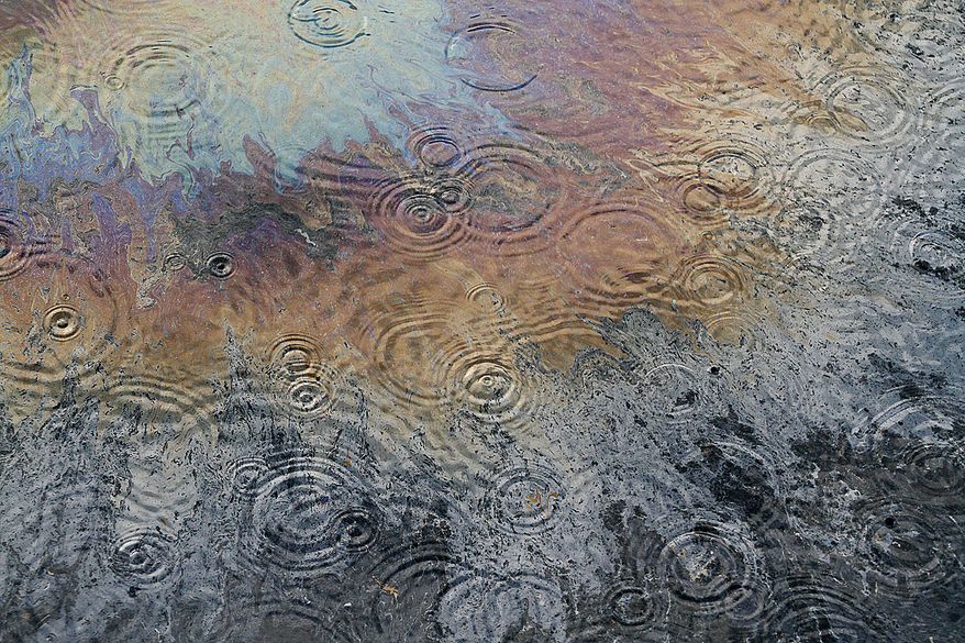 Rain falls on oil sheen on the surface of the Gulf of Mexico near the site of the Deepwater Horizon oil well leak off the coast of Louisiana Thursday, July 15, 2010. Crew members onboard the Pacific Responder oil skimming vessel prepared to skim oil this morning, but operations were put on standby after lightning was spotted nearby. (AP Photo/Patrick Semansky)
