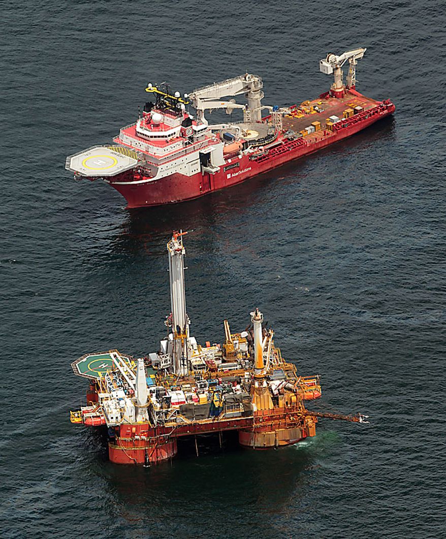 The Boa Sub C work boat, top, operates near the Q4000 drilling rig at the site of the Deepwater Horizon incident in the Gulf of Mexico Friday, July 16, 2010. The wellhead has been capped and BP is continuing to test the integrity of the well before resuming production. (AP Photo/Dave Martin)