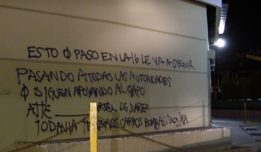 **FILE** A wall at a shopping center is covered by graffiti that reads in Spanish: &quot;What happened on the 16 (street) is going to keep happening to all the authorities that continue to support the Chapo (Guzman), sincerely, the Juarez Cartel. We still have car bombs (expletive) ha ha.&quot; Cartel assailants laid a trap for federal police and attacked them with a car bomb on July 15, the first time a drug cartel have used explosives to attack Mexican security forces, marking an escalation in the country&#39;s drug war. (Associated Press)