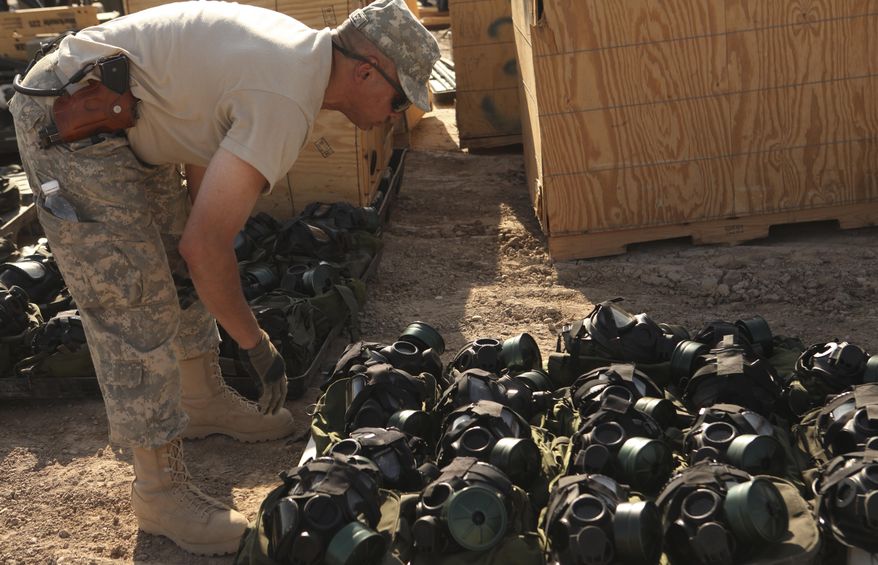 A U.S. Army soldier from the 49th Military Police Brigade counts gas masks on Sunday, July 18, 2010, at Camp Victory in Baghdad as the unit prepares to ship their equipment and belongings home. The soldiers, based in Fairfield, Calif., are soon to leave Iraq as part of the U.S. drawdown of forces, which begins in earnest next month. The number of soldiers in Iraq is expected to go from 77,500 currently in the country to 50,000 by Sept. 1. (AP Photo/Maya Alleruzzo)