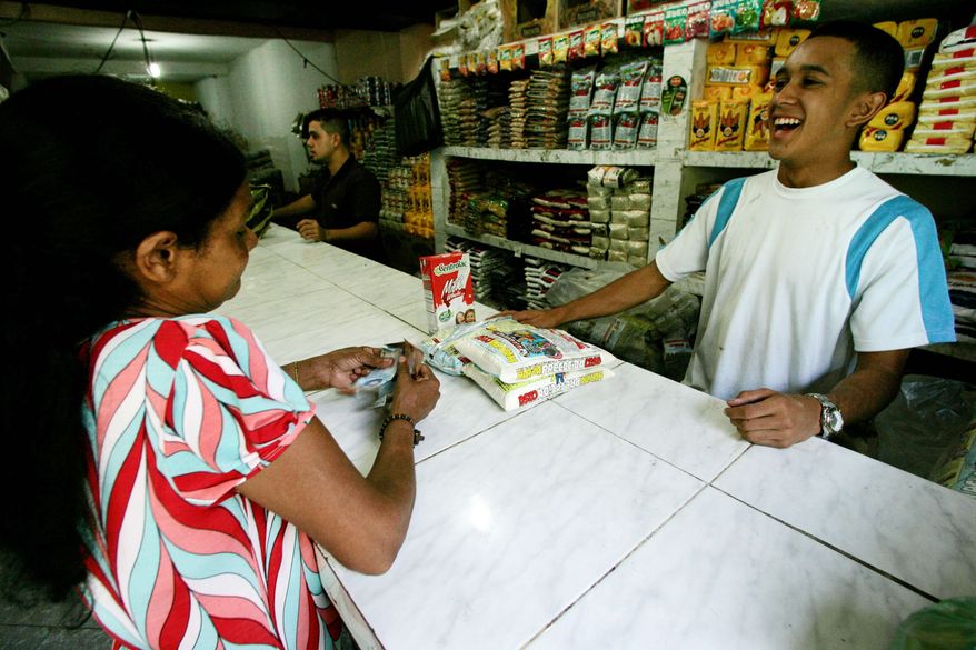 A customer buys groceries at Mercal, a government-owned market in Caracas. The markets are part of Mr. Chavez's effort to counter 31 percent inflation in a recession economy.