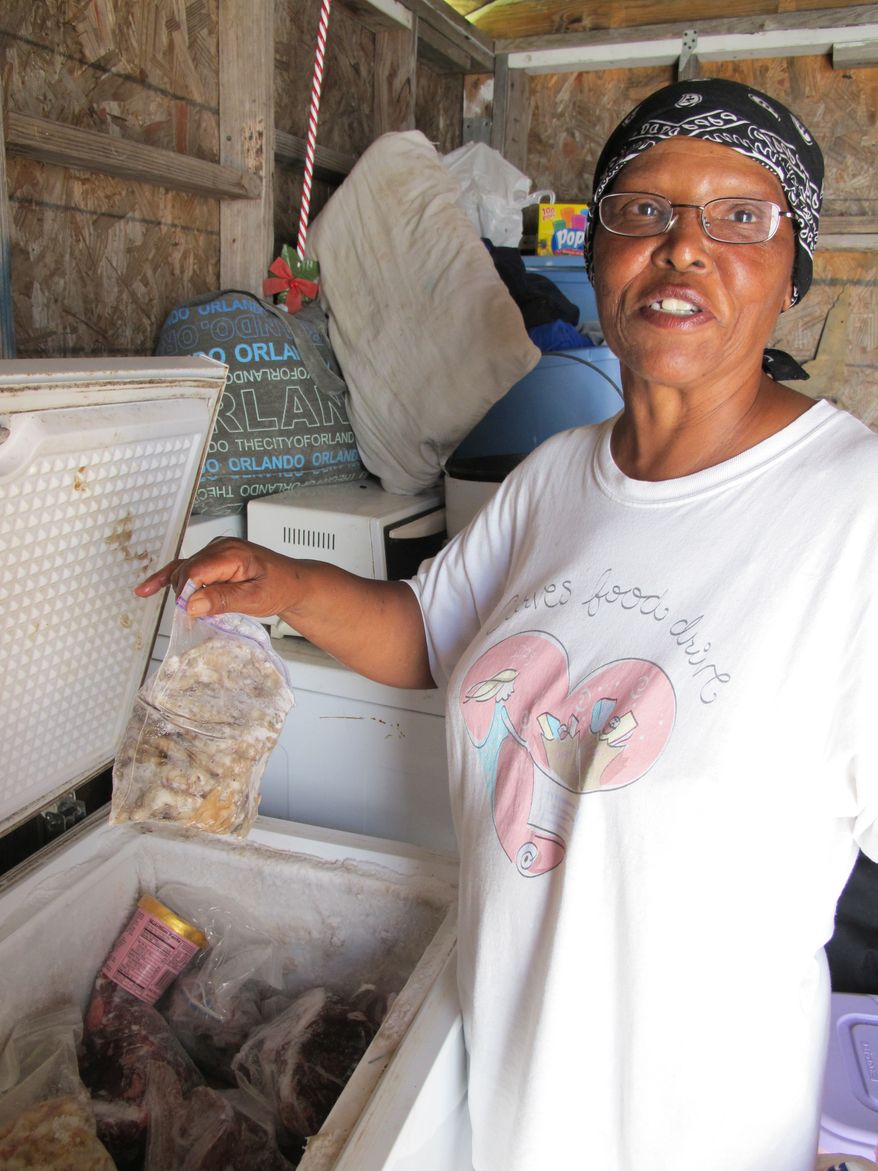 In a Thursday, July 8 photo, June Demolle, the wife of an oysterman in Pointe a la Hache, La., shows her kitchen pantry. It's stocked with canned goods from Second Harvest Food Bank and other charities that are helping fishermen and their families eat now that their main source of protein is cut off by the Gulf oil spill. ( AP Photo/Vicki Smith)