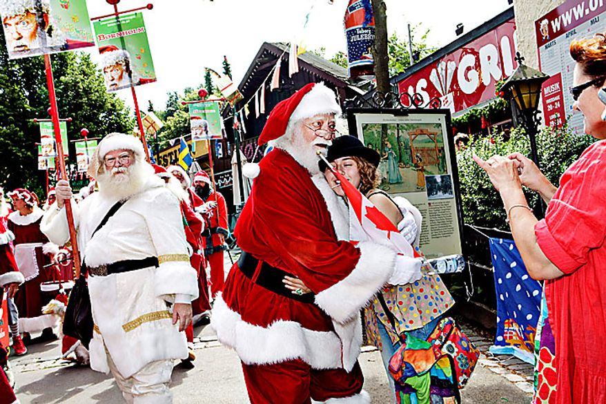 A group of Santas interact with visitors in the Dyrehavsbakken amusement park, north of Copenhagen, Denmark, Monday, July 19, 2010 for the World Santa Claus Congress, which has been held 52 times now at the amusement park. Every summer, Santas from the entire world get together at Bakken to spread some Christmas cheer, have fun, and enjoy a get-together. (AP Photo/Polfoto, Nanna Kreutzmann) 
