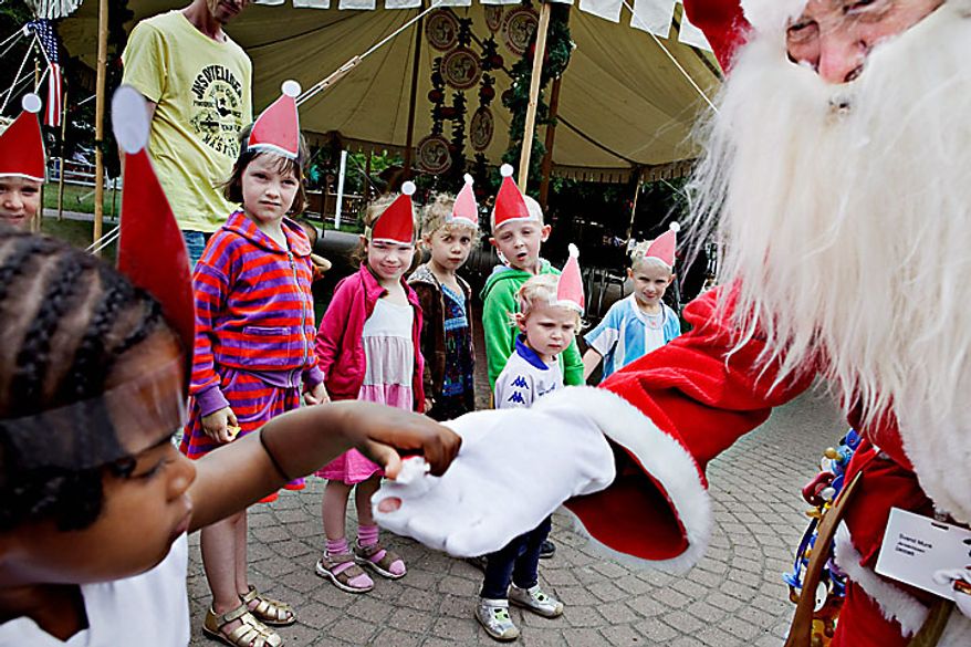 A  Santa interacts with children at the Dyrehavsbakken amusement park, north of Copenhagen, Denmark, Monday, July 19, 2010. Many have gathered for the World Santa Claus Congress, which has been held 52 times now at the amusement park. (AP Photo/Polfoto, Nanna Kreutzmann) 