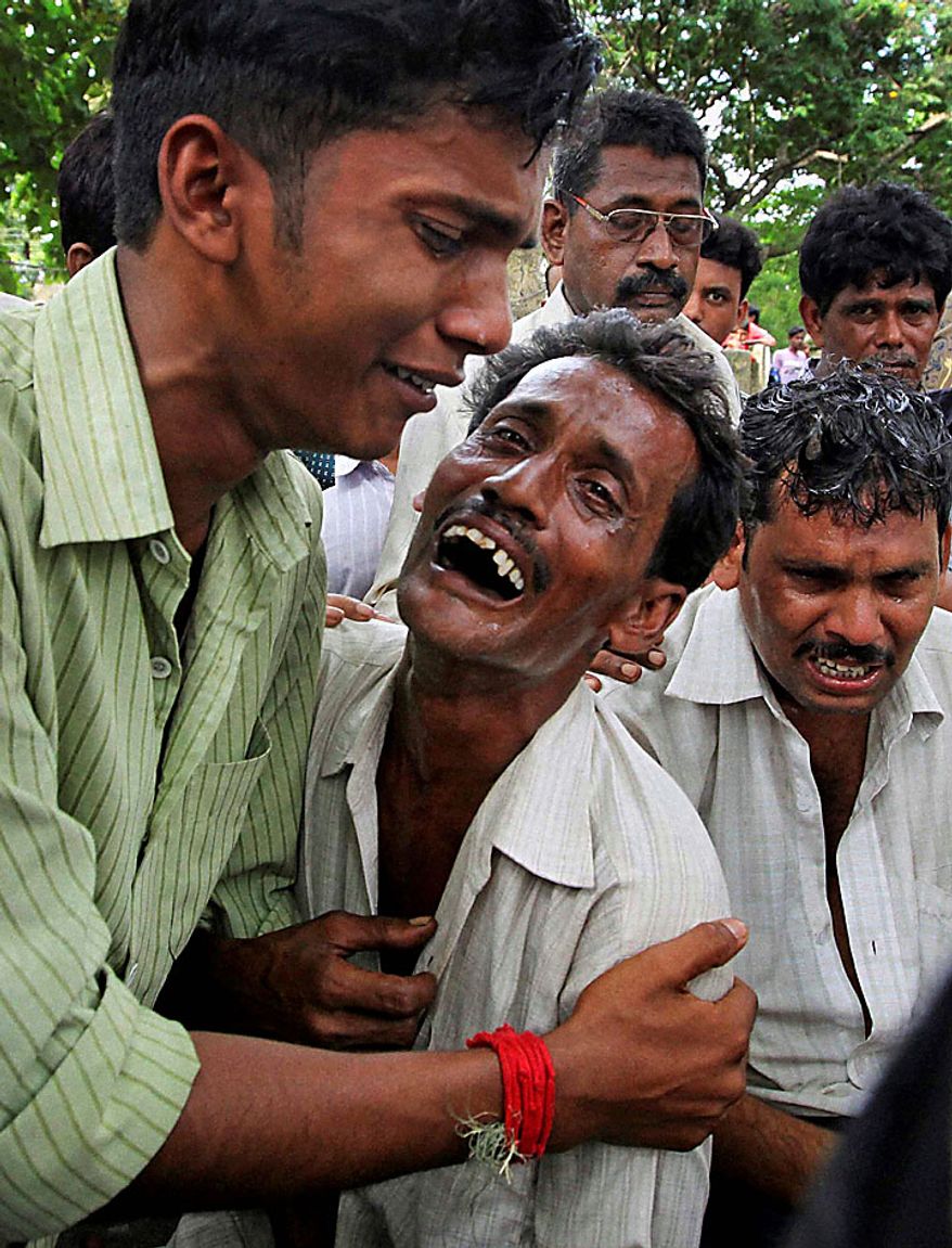 Relatives of victims break down outside a hospital in Birbhum district of West Bengal state, about 250 kilometers (155 miles) north of Calcutta, India, Monday, July 19, 2010. A speeding express train plowed into a stationary passenger train in eastern India on Monday, killing scores of people in a crash so powerful it sent the roof of one car flying onto an overpass. (AP Photo)