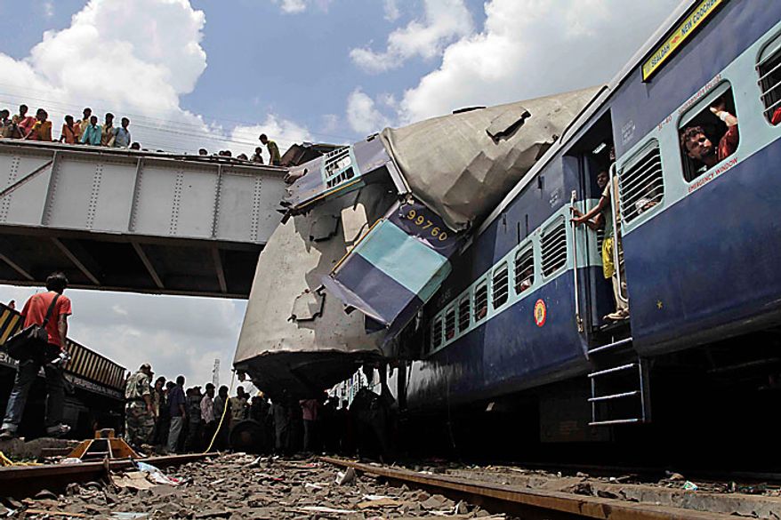 The roof of Uttarbanga Express&#39;s passenger car sits on top of Vananchal Express as rescue workers search for survivors at the site of an accident at Sainthia station, about 125 miles (200 kilometers) north of Calcutta, India, Monday, July 19, 2010. The speeding Uttarbanga Express train collided with stationary Uttarbanga Express at the station in eastern India early Monday, mangling the carriages and killing scores of people, railway police said. (AP Photo/Bikas Das)