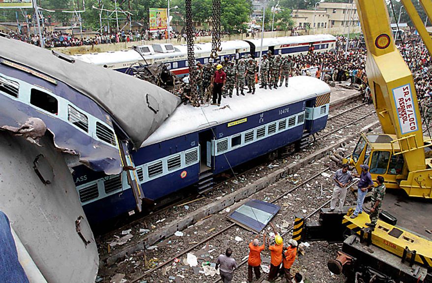 Local residents and rescue workers search for survivors at the site of a train accident at Sainthia station, about 125 miles (200 kilometers) north of Calcutta, India, Monday, July 19, 2010. A speeding express train collided with a passenger train at the station in eastern India early Monday, mangling the carriages and killing scores of people, railway police said. (AP Photo/Bikas Das)