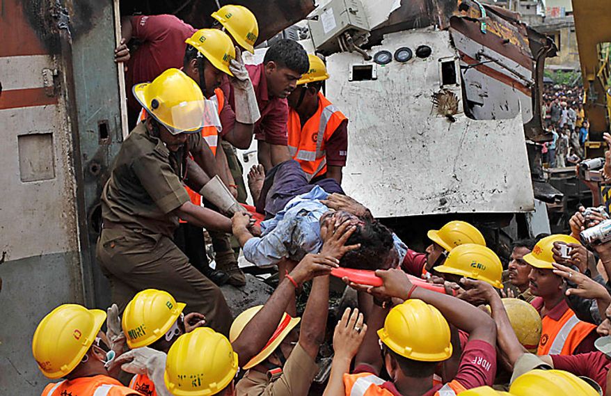 Indian rescue workers take out the body of the driver of the Uttarbanga Express at the site of an accident at Sainthia station, about 125 miles (200 kilometers) north of Calcutta, India, Monday, July 19, 2010. The speeding express train collided with a passenger train at the station in eastern India early Monday, mangling the carriages and killing scores of people, railway police said. (AP Photo/Bikas Das)