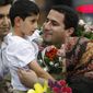Shahram Amiri, an Iranian nuclear scientist who disappeared a year ago, holds his 7-year-old son Amir Hossein as he arrives at the Imam Khomeini airport just outside Tehran Thursday, July 15, 2010. Iranian news agencies reported Wednesday that Mr. Amiri provided valuable information on the CIA. (AP Photo/Vahid Salemi)