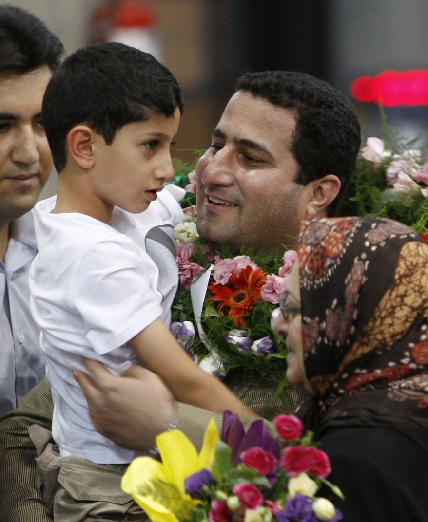 Shahram Amiri, an Iranian nuclear scientist who disappeared a year ago, holds his 7-year-old son Amir Hossein as he arrives at the Imam Khomeini airport just outside Tehran Thursday, July 15, 2010. Iranian news agencies reported Wednesday that Mr. Amiri provided valuable information on the CIA. (AP Photo/Vahid Salemi)