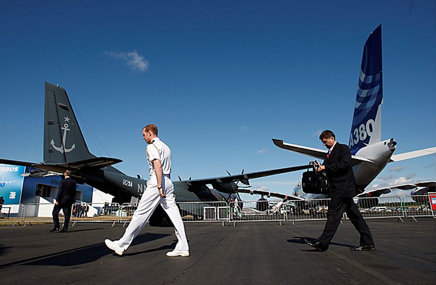 Visitors walk pass aircraft on display at the Farnborough International Airshow, Farnborough, Britain, Wednesday, July 21, 2010. Aircraft orders at the Farnborough International Airshow this week have reached $25 billion, indicating a rapid recovery in the sector, and more are expected on Wednesday. (AP Photo/Sang Tan)