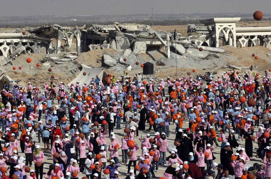 Thousands of Palestinian children throw basketballs to the air to celebrate their attempt to break the world record for the number of basketballs bounced simultaneously in the destroyed Gaza international airport in Rafah southern Gaza Strip, Thursday, July 22, 2010. The top U.N. aid official says more than 7,000 Gaza children have simultaneously dribbled basketballs for five minutes in an attempt to enter the Guinness Book of World Records. (AP Photo/Khalil Hamra)