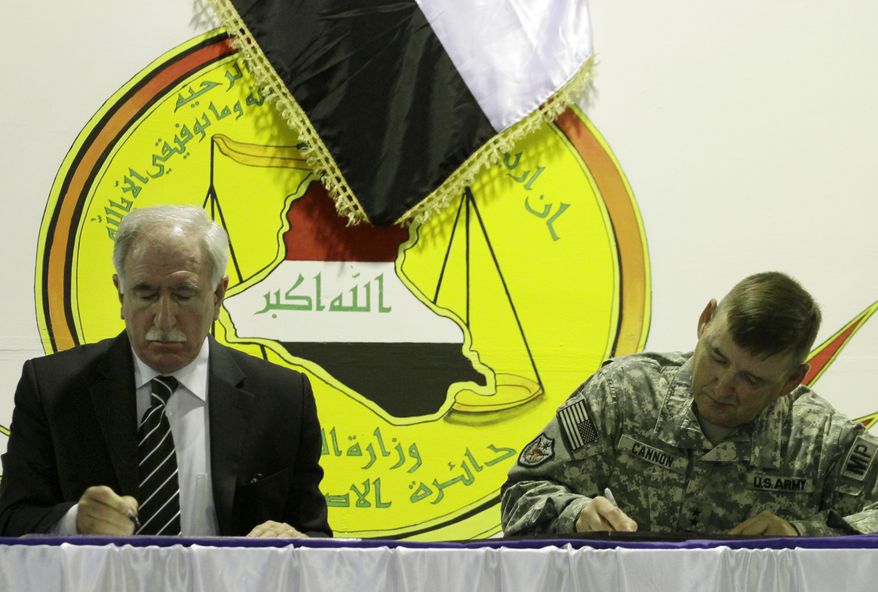 Iraq&#39;s Minister of Justice Dara Noureddin, left, and U.S. Army Maj. Gen. Jerry Cannon, right, sign documents handing the U.S. Theater Internment Facility at Camp Cropper to Iraqi control at a ceremony, Thursday, July 15, 2010 in Baghdad. (AP Photo/Maya Alleruzzo)