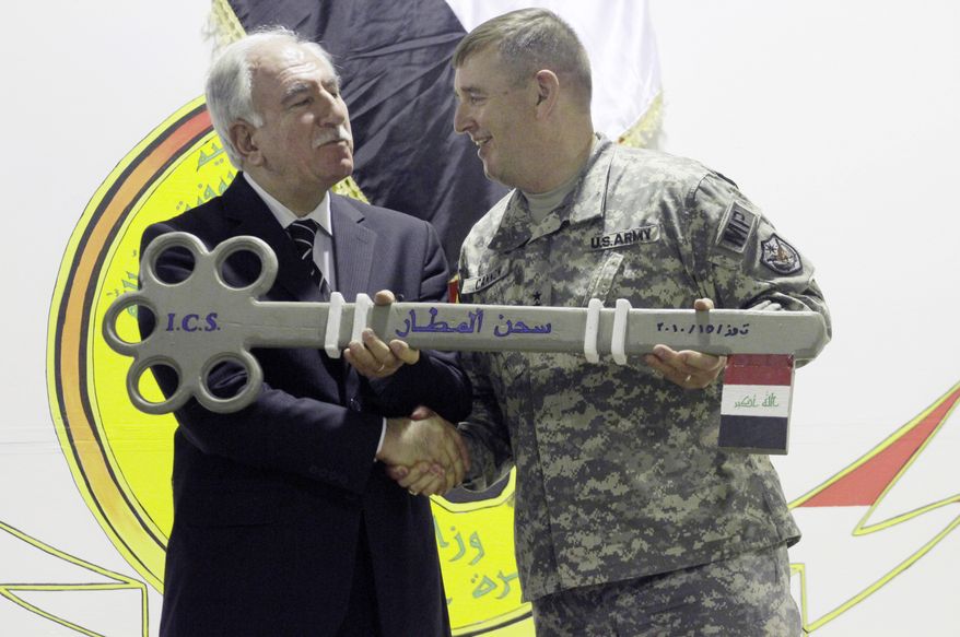 In this Thursday, July 15, 2010, file photo, Iraq&#39;s Minister of Justice Dara Noureddin, left, and U.S. Army Maj. Gen. Jerry Cannon, right, hold a symbolic key to the U.S. Theater Internment Facility at Camp Cropper during a ceremony transferring the facility to Iraqi control in Baghdad, Iraq. Iraq&#39;s justice minister says four al Qaeda-linked detainees have escaped from the Baghdad area prison that was handed over by the U.S. to Iraqi authorities a week ago. (AP Photo / Maya Alleruzzo, File)