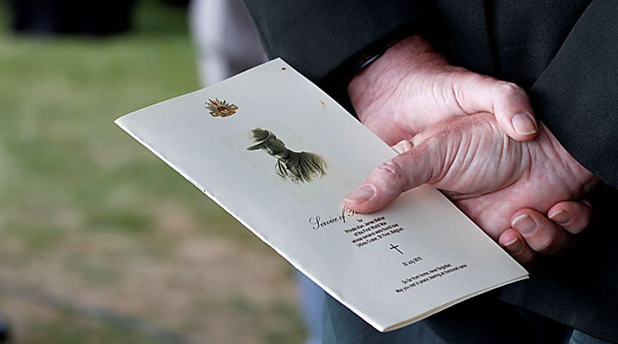 A man holds the funeral program of Australian World War One soldier, Private Alan James Mather during a re-burial ceremony at Prowse Point Cemetery in Ploegsteert, Belgium on Thursday, July 22, 2010. Mr. Mather, originally from Invernell, NSW, Australia was one of 216,000 men from Australia, New Zealand and the UK who fought in the Battle of Messines from June 7-14, 1917. The body of Mr. Mather was discovered by a British archeological team in 2008 and further DNA tests by a Belgian laboratory revealed his full identity. (AP Photo/Virginia Mayo)