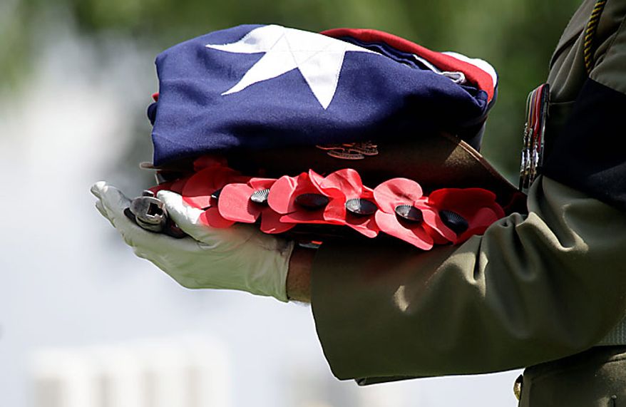 A member of the Australian Federation Guard holds the effects of Australian WWI soldier, Private Alan James Mather, during a re-burial ceremony at Prowse Point Cemetery in Ploegsteert, Belgium on Thursday, July 22, 2010. Mr. Mather, originally from Invernell, NSW, Australia, was one of 216,000 men from Australia, New Zealand and the UK who fought in the Battle of Messines from June 7-14, 1917. (AP Photo/Virginia Mayo)
