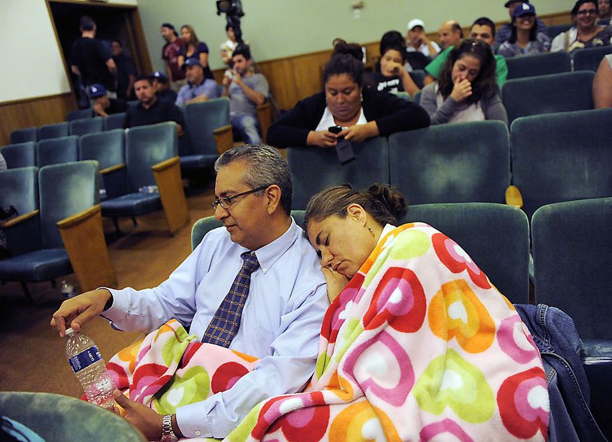 Coco Ceja, right, of Bell, Calif., falls asleep on the shoulder of her husband Marcelino as they wait to hear from city officials following a lengthy closed-door meeting of the Bell City Council, Thursday, July 22, 2010, in Bell, Calif. Revelations about Bell city leaders' pay has sparked anger in a blue-collar town that is one of the poorest in Los Angeles County. Bell's police chief and two top city administrators agreed to resign Thursday night during the closed-door meeting. (AP Photo/Chris Pizzello)