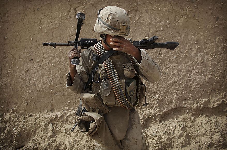 United States Marine LCpl. Brian Quinnones from Bravo Company of the 1st Battalion of the 2nd Marines reacts following a gun battle as part of an operation to clear the area of insurgents near Musa Qaleh, in northern Helmand Province, southern Afghanistan, Friday, July 23, 2010. (AP Photo/Kevin Frayer)