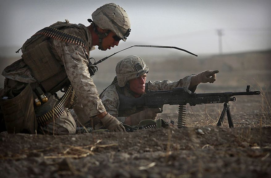 United States Marine Cpl. Jesse Hopkins, right, from Bravo Company of the 1st Battalion of the 2nd Marines points to an area where small arms fire originated from as LCpl. Steven Paratore brings extra ammunition during a gun battle as part of an operation to clear the area of insurgents near Musa Qaleh, in northern Helmand Province, southern Afghanistan, Friday, July 23, 2010. (AP Photo/Kevin Frayer)