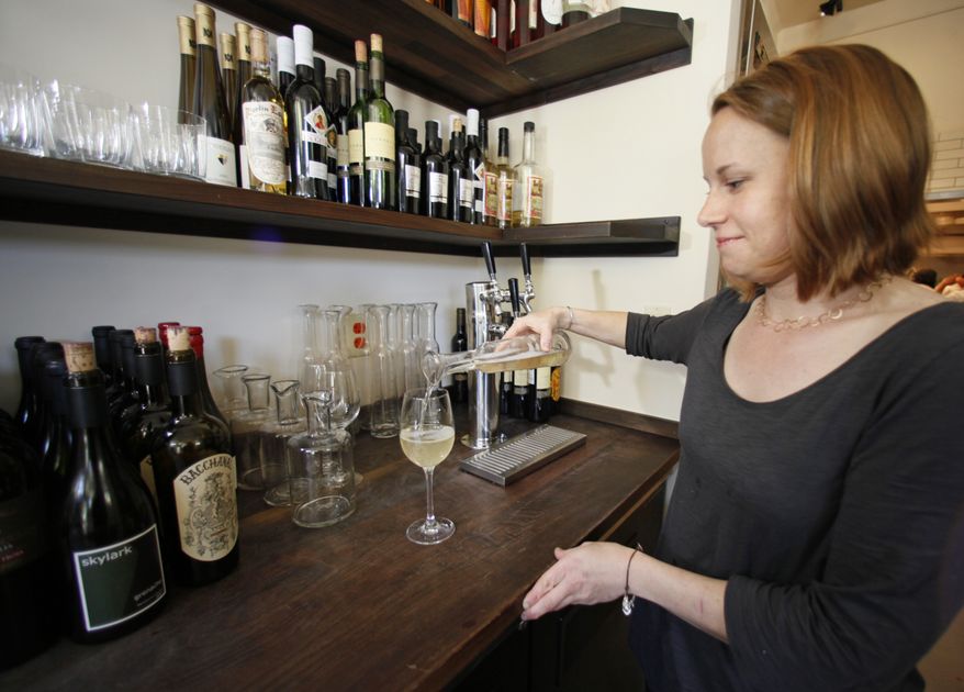 Chef and owner Melissa Perello pours a glass of the house white wine from a pitcher etched with one ounce markings after drawing it from a tap at her Frances restaurant in San Francisco, Friday, July 23, 2010. Customers at the restaurant are charged $1 for each ounce they consume. Ordering wine by the glass used to mean scant choices and bland options. That's changed, with restaurants amping up the volume on what's available by the glass and making sure that the wines poured are at optimal freshness. (AP Photo/Eric Risberg)