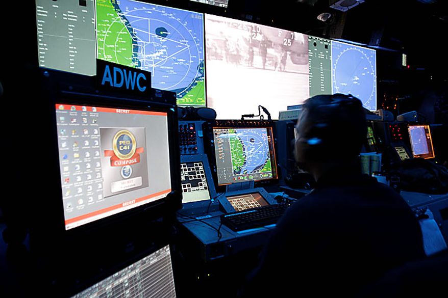 A crew member aboard the Nimitz-class USS George Washington works in the Combat Defense Center during joint military exercises between the U.S. and South Korea in South Korea's East Sea on Monday, July 26, 2010. U.S. and South Korean warships and helicopters practiced anti-submarine maneuvers off the Korean Peninsula Monday that officers said they hope would serve as a warning to Pyongyang that aggression in the region would not be tolerated. (AP Photo/ Lee Jin-man, Pool)