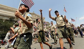 Scouts and Scout leaders wave to the reviewing stand during the Boy Scout Association Grand Centennial Parade along Constitution Avenue in Washington on Sunday, July 25, 2010. (AP Photo/The Free Lance-Star, Peter Cihelka)