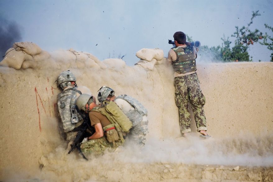 HELP ON THE WAY: An Afghan soldier fighting alongside U.S. troops launches a grenade during a clash in Kandahar. President Obama will get a $59 billion emergency war-spending bill to sign to fund his U.S. troop surge. (Associated Press)
