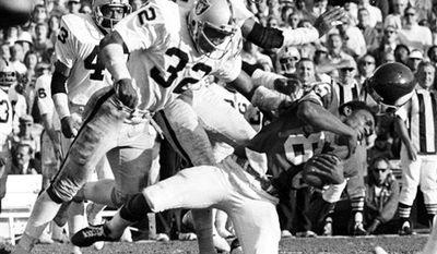 FILE-This Jan. 9, 1977 file photo shows Minnesota Vikings wide receiver Sammy White losing his helmet as two Oakland Raiders hit him in the Super Bowl XI game at Pasadena, Calif. Raiders are, defensive backs Jack Tatum (32) and Skip Thomas. Tatum, the All-Pro safety for the Oakland Raiders best known for his hit that paralyzed Darryl Stingley in an NFL preseason game in 1978, has died. He was 61.  Nicknamed &quot;The Assassin,&quot; Tatum died of a heart attack Tuesday July 27, 2010 in Oakland, according to friend and former Ohio State teammate John Hicks. (AP Photo/Richard Drew,File)