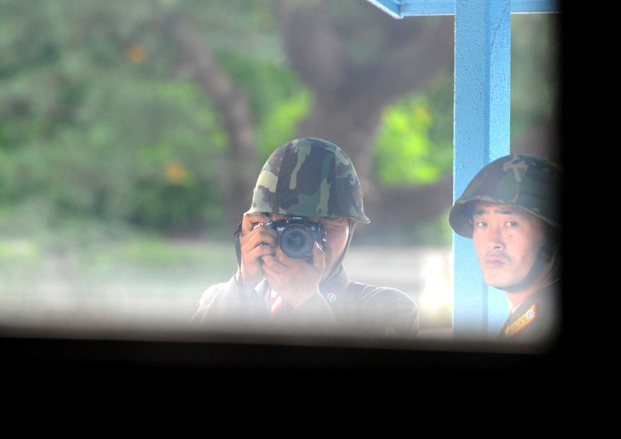 A North Korean soldier takes pictures of the southern side of the cross-border village of Panmunjom on Tuesday, July 27, 2010. Both Koreas and the United States on Tuesday marked the 57th anniversary of the signing of the Korean War armistice against the backdrop of U.S.-South Korean military drills. (AP Photo/Kim Jae-hwan, Pool)
